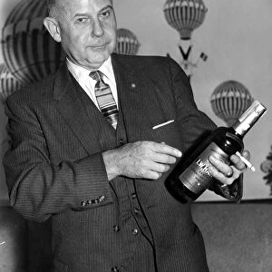Vice Admiral William J. Marshall holding a bottle of bourbon and a cigarette. 2