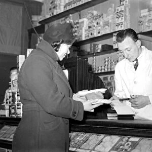 War 1939-1940. Rationing - cutting out the coupons for sugar at the grocer s. 8