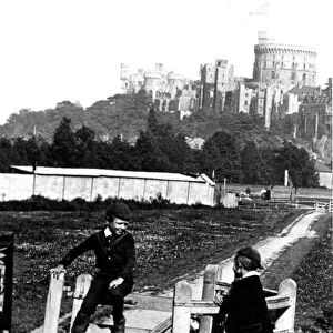 Four young boys playing games by the kissing gate with Windsor Castle in the background