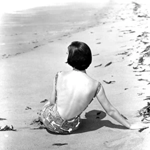 A young woman relaxing on the beach April 1953