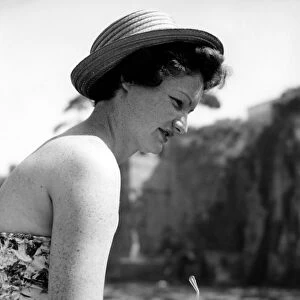 A young woman in a strapless dress enjoys the summer sunshine