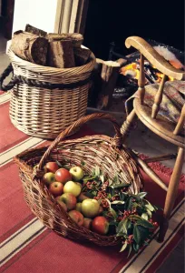 Big decorative basket of Coxs apples with sprays of ornamental berries by open fireplace Big decorative basket of Coxs apples with sprays of ornamental berries by open fireplace