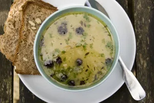 Bowl of chicken soup with Cypriot trahanas, purple sprouting broccoli and chopped parsley Bowl of chicken soup with Cypriot trahanas, purple sprouting broccoli and chopped parsley
