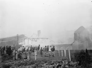 Children climb on a fence to watch the fire at the Vickers factory in Crayford, Kent Children climb on a fence to watch the fire at the Vickers factory in Crayford, Kent
