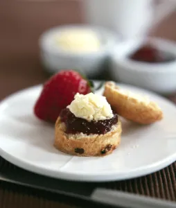 Classic scone with clotted cream and jam with fresh strawberry served with afernoon tea Classic scone with clotted cream and jam with fresh strawberry served with afernoon tea