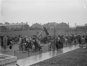 Crayford playground is opened by J T Eden. Children play on the swings Crayford playground is opened by J T Eden. Children play on the swings