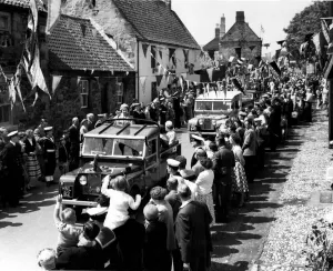 Driving through the streets in a Land Rover the Queen smiles at the crowds on either side Driving through the streets in a Land Rover the Queen smiles at the crowds on either side