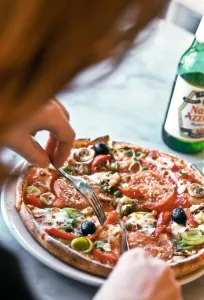 Eating pizza in Pizza Express restaurant, with bottle of Nastro Azzuro beer. credit Eating pizza in Pizza Express restaurant, with bottle of Nastro Azzuro beer. credit