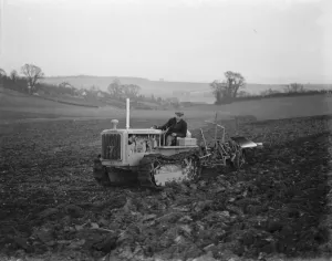 A farmer using his diesel caterpillar tractor to plough a field in Farningham, Kent A farmer using his diesel caterpillar tractor to plough a field in Farningham, Kent