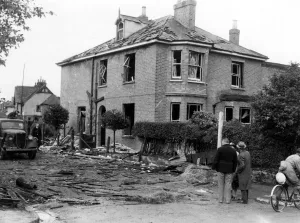 A house showing considerable damage, surrounded by debris after a near miss A house showing considerable damage, surrounded by debris after a near miss