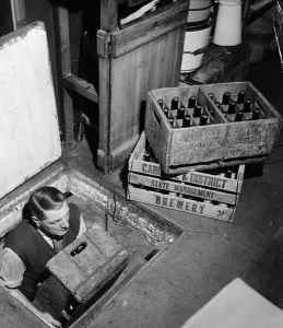 Joe, the landlord, brings up bottles of beer from the cellar to sell at the Globe Tavern Joe, the landlord, brings up bottles of beer from the cellar to sell at the Globe Tavern