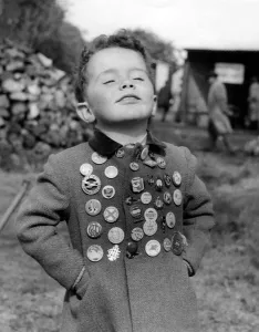Kent. Timothy Elliott aged 3 years proudly displays his collection of badges. 1955 Kent. Timothy Elliott aged 3 years proudly displays his collection of badges. 1955