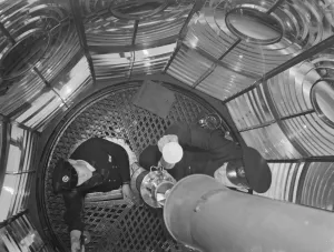 The lighthouse keepers in the light chamber interior of Dungeness lighthouse in Kent The lighthouse keepers in the light chamber interior of Dungeness lighthouse in Kent
