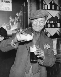 Man pours ground ginger in his pint of beer Man pours ground ginger in his pint of beer