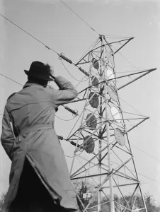 A man stands looking up at an electricity pylon in Shoreham, Kent. 1936 A man stands looking up at an electricity pylon in Shoreham, Kent. 1936