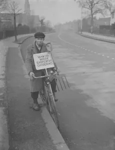 Mr F J Archer rides his bicycle with a placard advertising his services Mr F J Archer rides his bicycle with a placard advertising his services