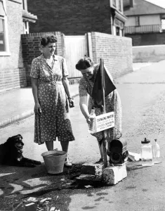 Mrs Gardaner and Mrs Weatherall draw drinking water from stand pipes which have been Mrs Gardaner and Mrs Weatherall draw drinking water from stand pipes which have been