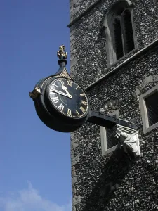 Ornate clock on a wall bracket on the facade of a church, Canterbury, Kent, England Ornate clock on a wall bracket on the facade of a church, Canterbury, Kent, England