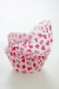 Paper cases for making muffins and fairy cakes - decorated with small red hearts credit Paper cases for making muffins and fairy cakes - decorated with small red hearts credit