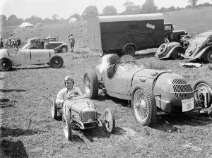 Peter McClure sits in a toy race car, parked next to the real thing, in Lullingstone Peter McClure sits in a toy race car, parked next to the real thing, in Lullingstone