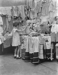Petts Wood fete in Kent. A little girl at a garment stall. 1937 Petts Wood fete in Kent. A little girl at a garment stall. 1937