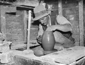 Pottery maker Mr Sadler moulding clay on a potters wheel. 1938 Pottery maker Mr Sadler moulding clay on a potters wheel. 1938