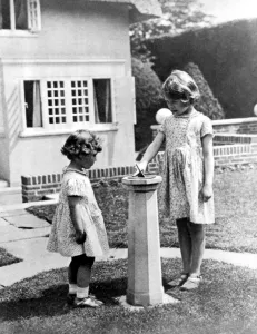 Princesses Elizabeth and Margaret Rose in the grounds of the model house presented Princesses Elizabeth and Margaret Rose in the grounds of the model house presented