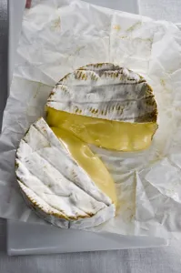 Whole round Camembert cheese cut in half showing ripe runny interior credit: Marie-Louise Whole round Camembert cheese cut in half showing ripe runny interior credit: Marie-Louise
