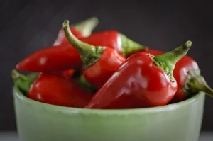 Shiny red chilli peppers in green bowl. Shorter depth of field. credit: Marie-Louise Shiny red chilli peppers in green bowl. Shorter depth of field. credit: Marie-Louise