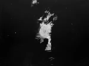 The silhouetted figure of a man can be seen against the flames from the fire at the The silhouetted figure of a man can be seen against the flames from the fire at the