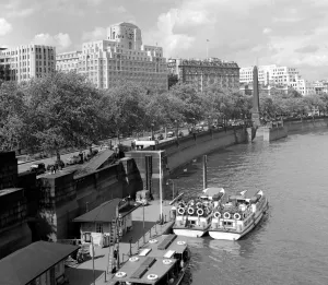 Thames river boats moored on the Victoria Embankment near to Cleopatras Needle with Thames river boats moored on the Victoria Embankment near to Cleopatras Needle with