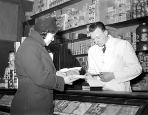 War 1939-1940. Rationing - cutting out the coupons for sugar at the grocer's. 8 War 1939-1940. Rationing - cutting out the coupons for sugar at the grocer's. 8