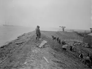Workers maintaining the river defences and doing repairs on the river wall and embankment Workers maintaining the river defences and doing repairs on the river wall and embankment