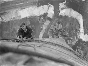 A workman climbs up on of the chimneys of the new coal electric power station under A workman climbs up on of the chimneys of the new coal electric power station under