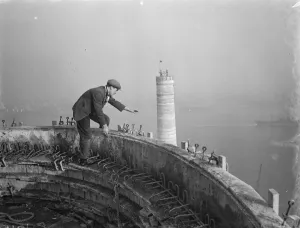A workman waves down from one of the chimneys of the new coal electric power station A workman waves down from one of the chimneys of the new coal electric power station