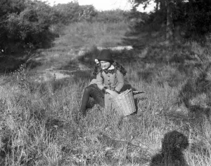 A young girl collecting acorns for feeding pigs and sheep. 31 October 1916 A young girl collecting acorns for feeding pigs and sheep. 31 October 1916