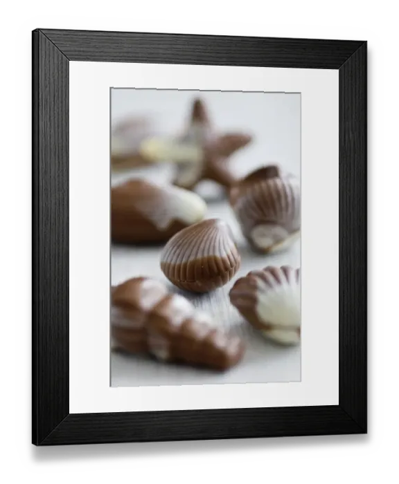 Framed Print : Selection of shell shaped chocolates on white surface. credit: Marie-Louise Avery Framed Print : Selection of shell shaped chocolates on white surface. credit: Marie-Louise Avery