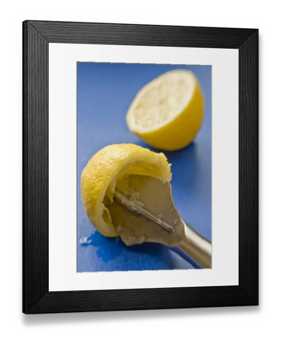 Framed Print : Squeezing halved elmon with reamer on blue surface credit: Marie-Louise Avery / Framed Print : Squeezing halved elmon with reamer on blue surface credit: Marie-Louise Avery /