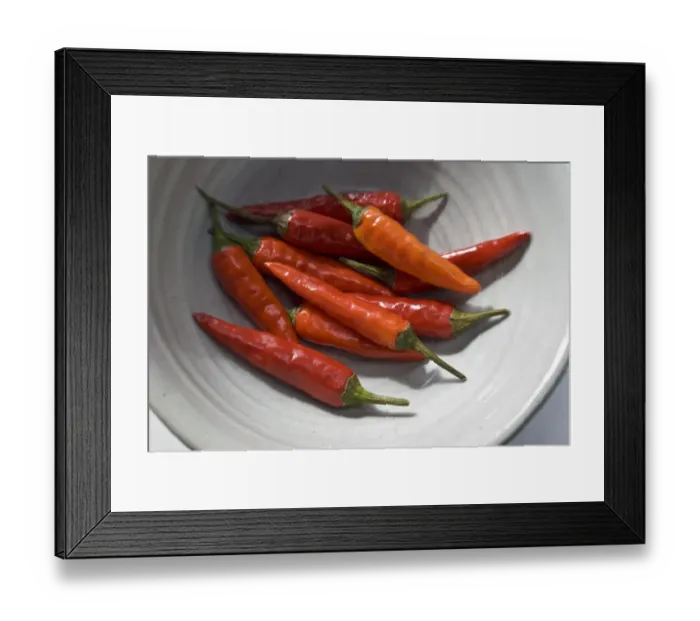 Framed Print : Small hot birds eye chilli peppers arranged on white surface. credit: Marie-Louise