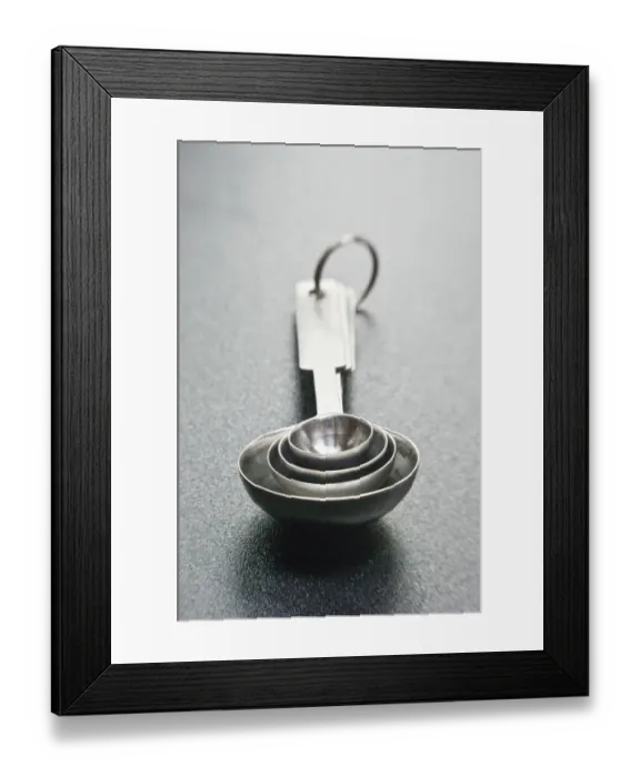 Framed Print : Stainless steel set of measuring spoons, on dark surface. credit: Marie-Louise Framed Print : Stainless steel set of measuring spoons, on dark surface. credit: Marie-Louise