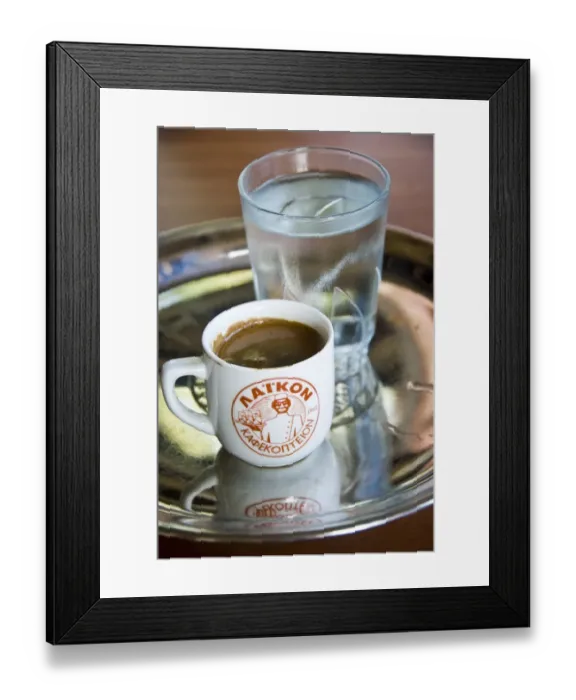 Framed Print : Little cup of strong Greek coffee, with glass of water on tray on table of hillside
