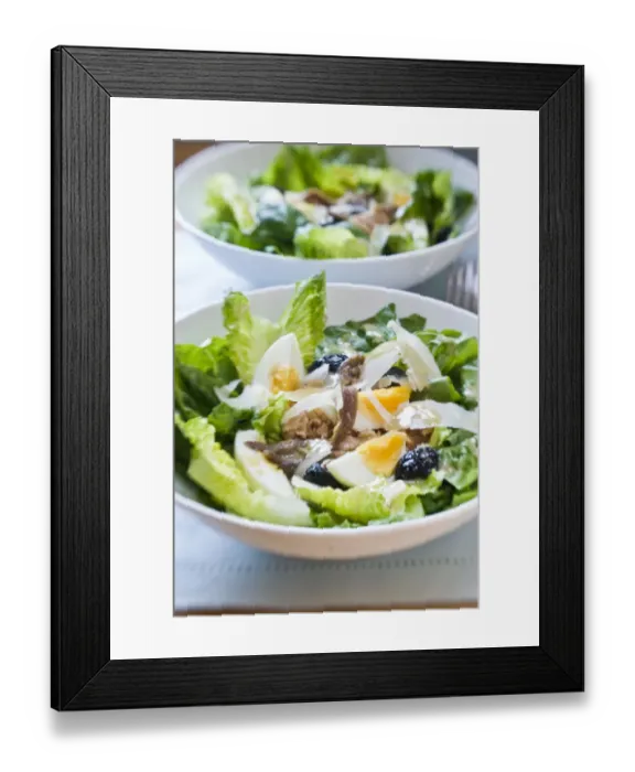 Framed Print : White bowl of classic Salade Nicoise, with vinaigrette credit: Marie-Louise Avery