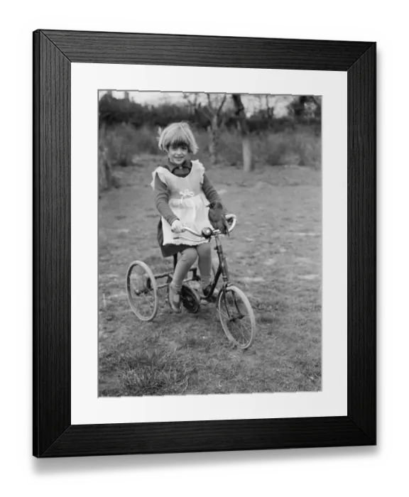 Framed Print : Little Ann Bowers playing on her tricycle with her tame jackdaw sitting on the handlebars