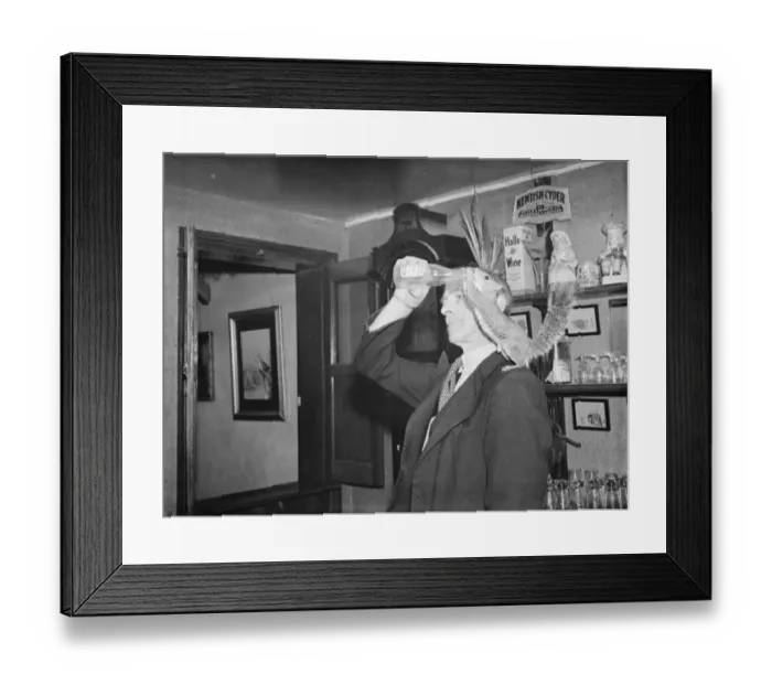 Framed Print : A man gives a drink to a tamed squirrel that is perched on his shoulder Framed Print : A man gives a drink to a tamed squirrel that is perched on his shoulder
