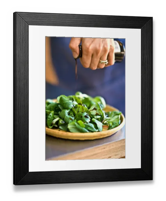 Framed Print : Drizzling balsamic vinegar onto lambs lettuce in pottery dish. credit: Marie-Louise