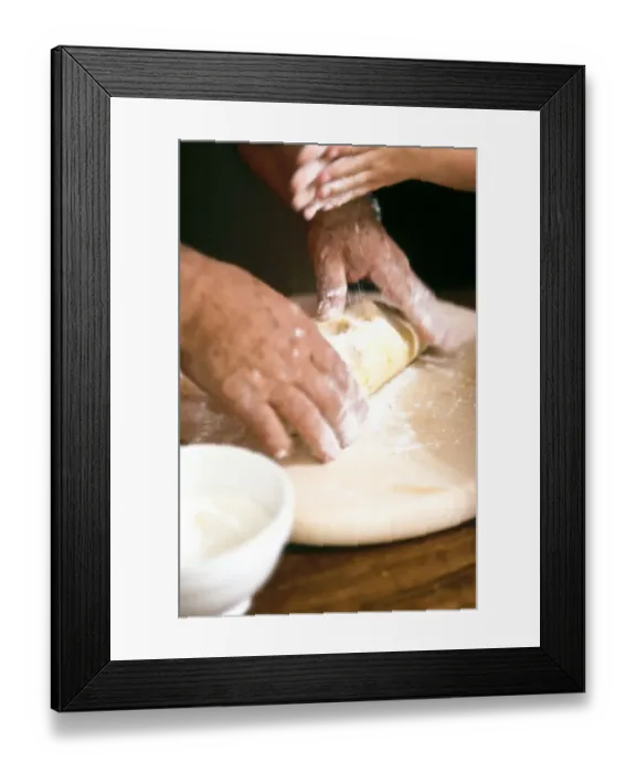 Framed Print : Chef kneading and rolling pastry with little girl helping - hands only shown credit