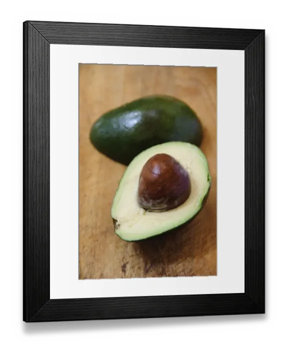 Framed Print : Whole and cut fresh avocado pear on wooden background credit: Marie-Louise Avery