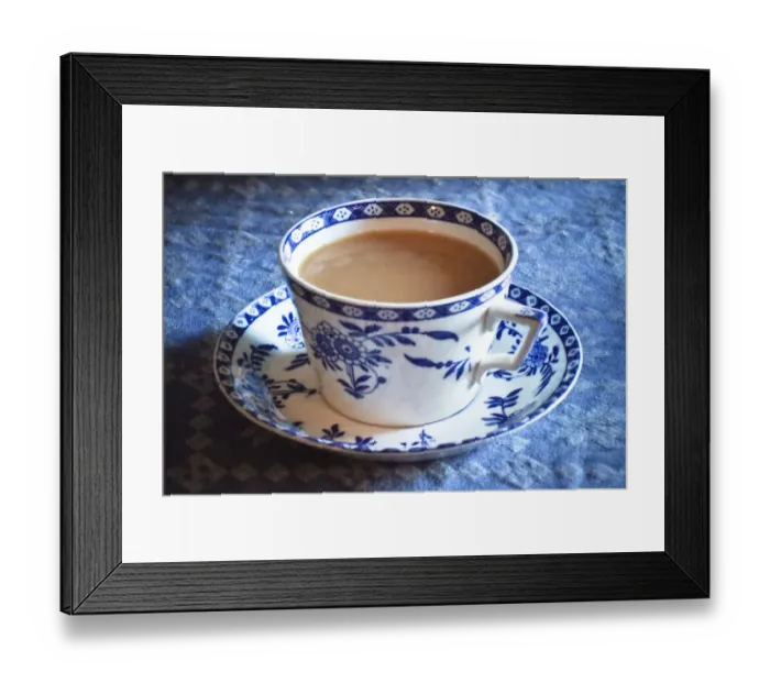 Framed Print : Antique blue and white cup and saucer of Indian tea with milk, on blue tablecloth Framed Print : Antique blue and white cup and saucer of Indian tea with milk, on blue tablecloth