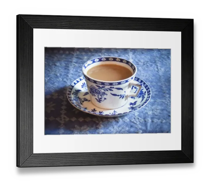 Framed Print : Antique blue and white cup and saucer of Indian tea with milk, on blue tablecloth Framed Print : Antique blue and white cup and saucer of Indian tea with milk, on blue tablecloth