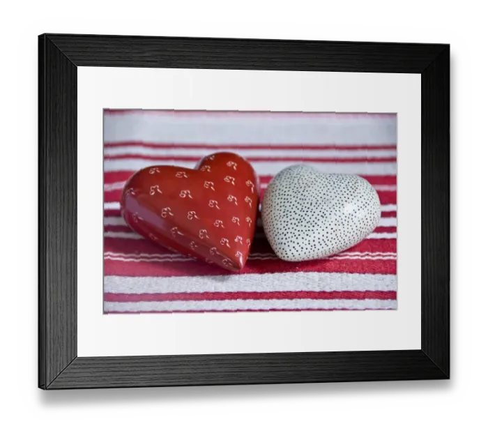 Framed Print : Two heart shaped soapstone paperweights, on striped table runner. credit: Marie-Louise Framed Print : Two heart shaped soapstone paperweights, on striped table runner. credit: Marie-Louise